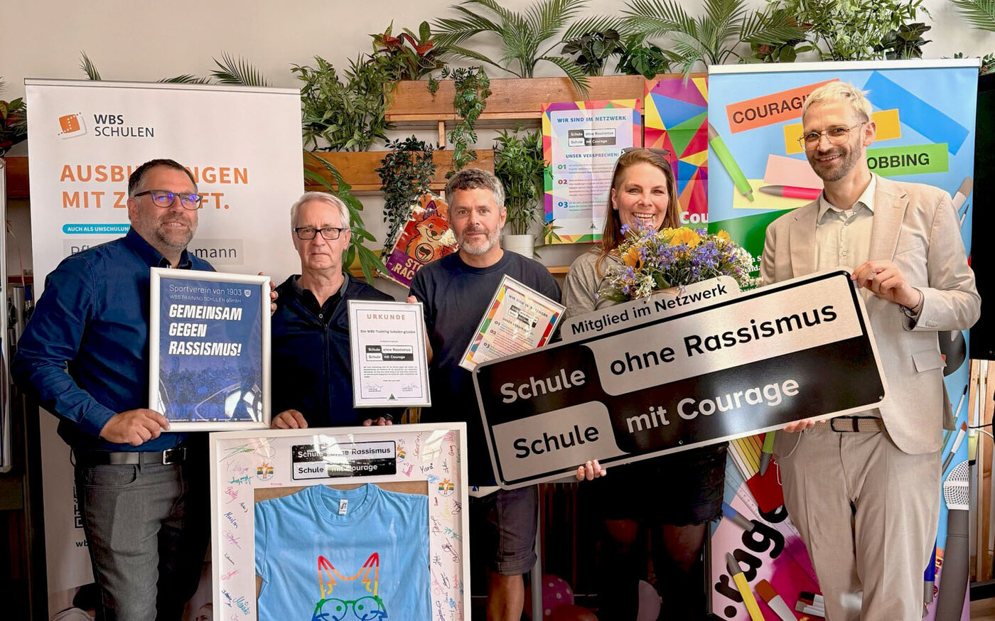 Vertreter:innen der WBS SCHULEN in Berlin präsentieren die Auszeichnung „Schule ohne Rassismus – Schule mit Courage“. Die Initiative steht für Vielfalt, Respekt und demokratische Werte im Bildungsalltag.