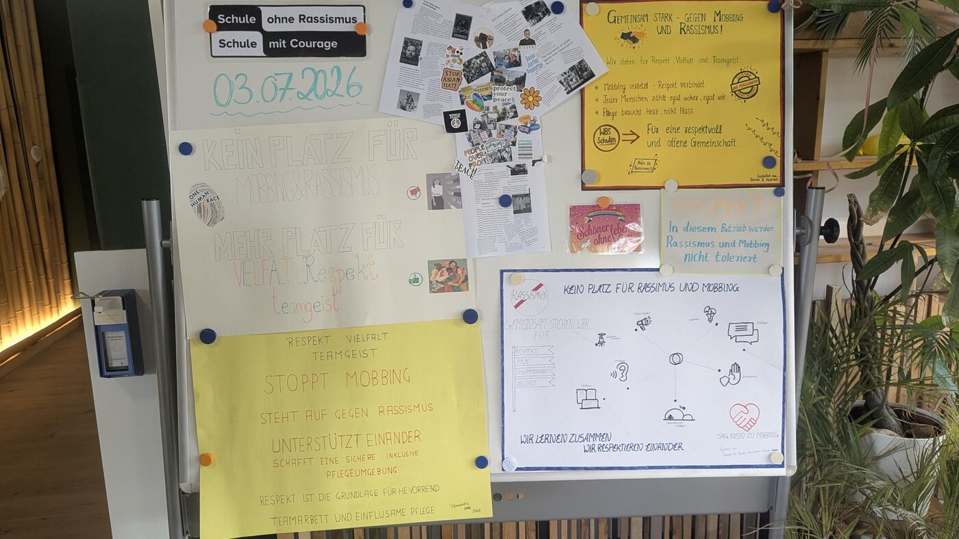 Aushangwand in einem Schulgebäude mit einer Urkunde des Netzwerks „Schule ohne Rassismus – Schule mit Courage“, ergänzenden Informationsmaterialien und Beiträgen zum Thema Vielfalt, Respekt und Antidiskriminierung. Die Ausstellung dokumentiert das Engagement der Schule für ein diskriminierungsfreies Miteinander.