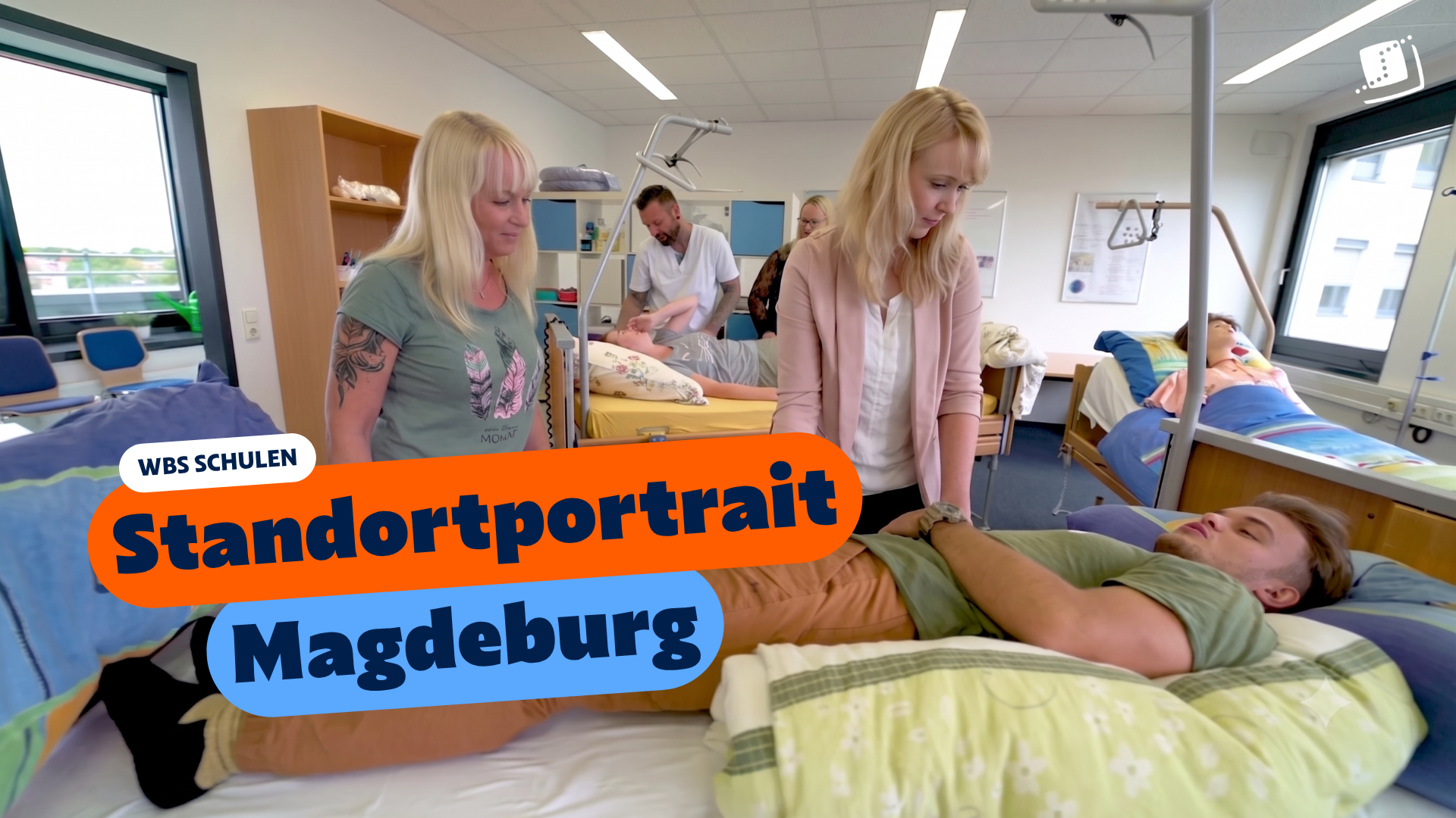 Praxisnaher Unterricht in einem Pflegeraum: Mehrere Lernende üben an Pflegebetten verschiedene Pflegesituationen, während Lehrkräfte oder Betreuungspersonen Anleitungen geben. Im Bild eingeblendet sind die Texte „WBS SCHULEN“, „Standortportrait“ und „Magdeburg“.